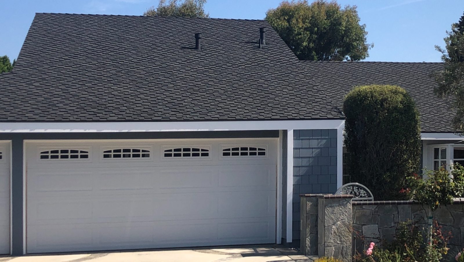 A home with a dark composition-shingle roof and a white two-car garage.